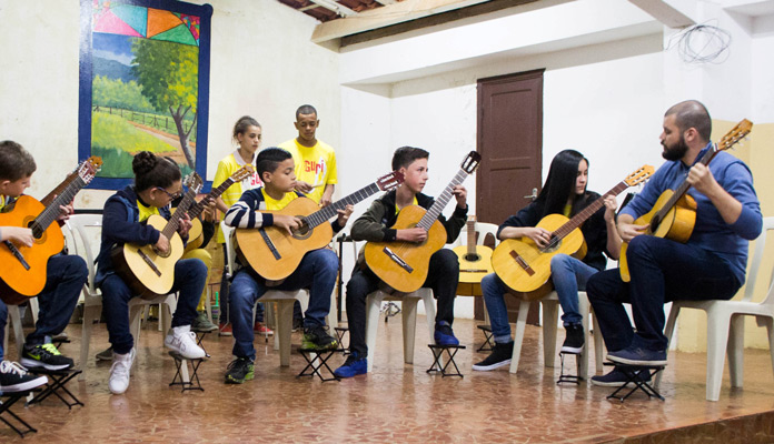 Alunos aprendem violão; aulas são de graça (Foto: Assessoria de Imprensa da PMI)