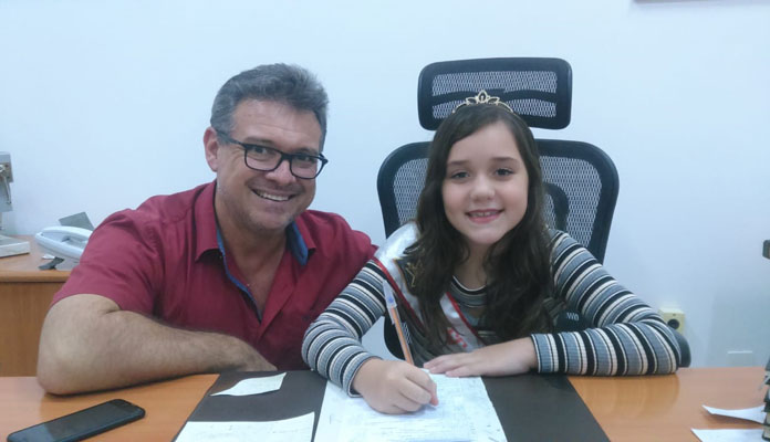 Izabelly, de 9 anos, conheceu o gabinete e mostrou a faixa de miss que ganhou no concurs (Foto: Divulgação)